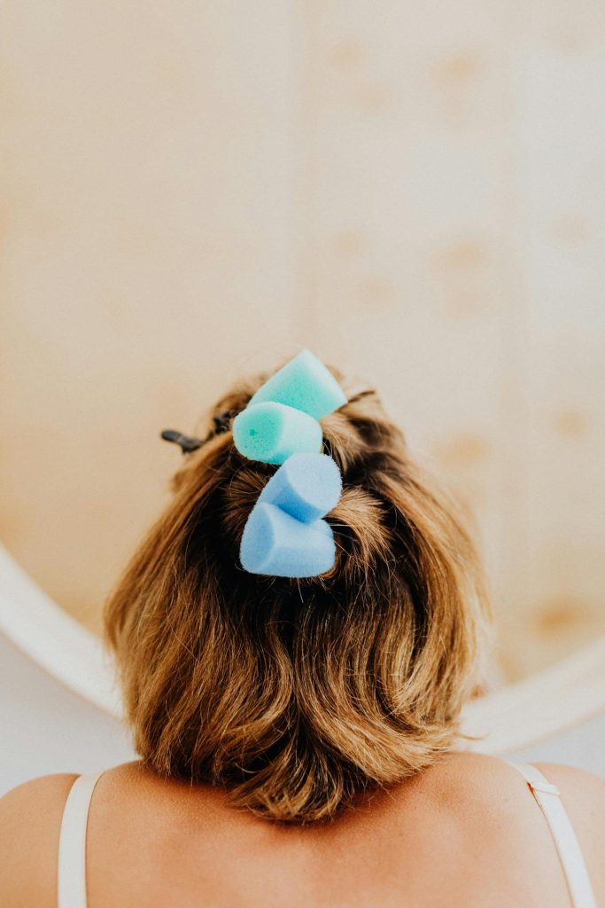 Back View of Woman with Hair Curlers on Her Head